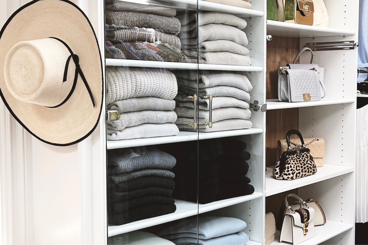 Organized closet in a Newport Beach home with folded sweaters and handbag storage designed for clear visibility and easy everyday use.