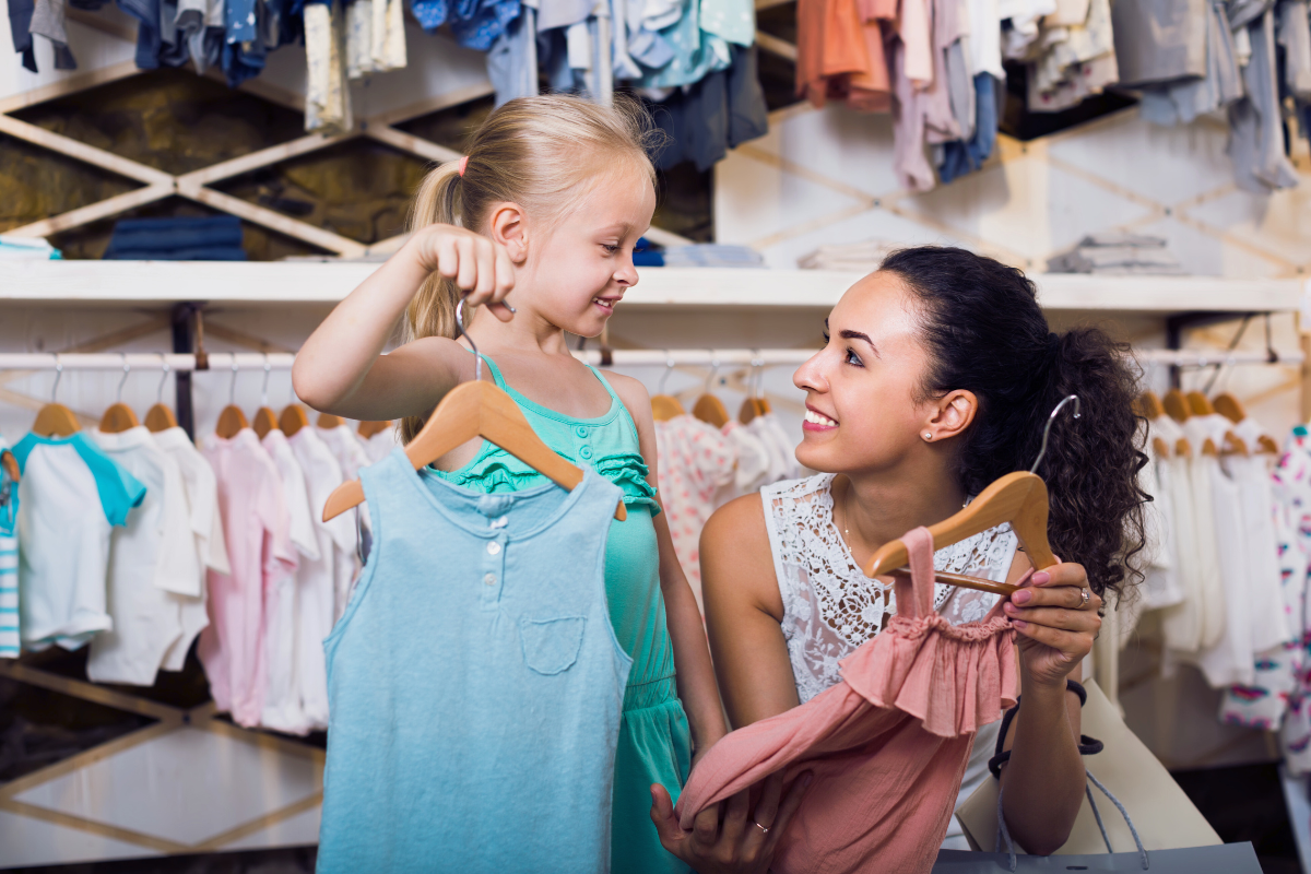 Mother and daughter shopping for children’s clothing together while planning a back-to-school wardrobe.