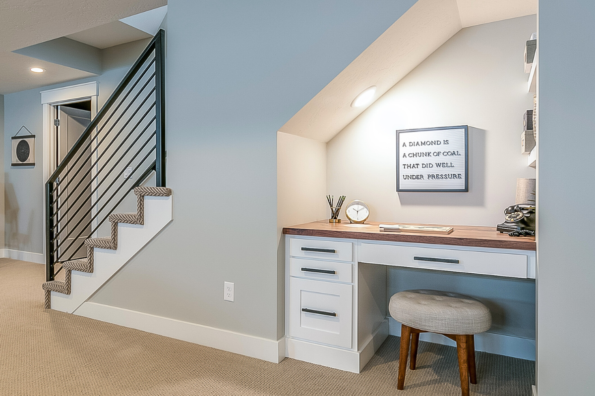 Organized homework zone under the stairs with built-in drawers, a work surface, and storage for everyday school supplies.