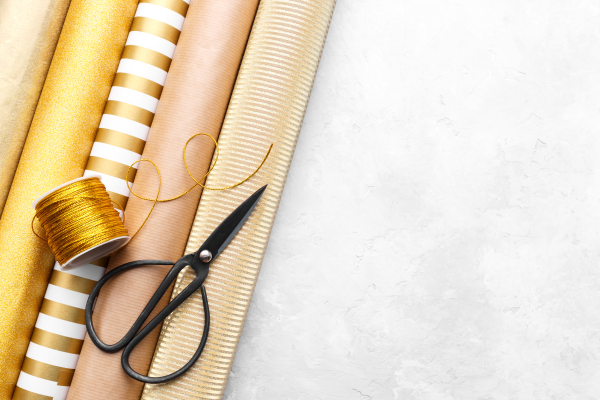 Gift wrapping paper, ribbon, and tools organized together in a functional wrapping station.