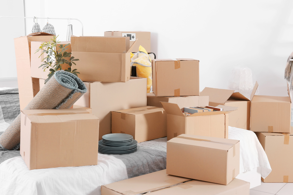 Cardboard moving boxes staged in a bedroom before unpacking during a Los Angeles home move.