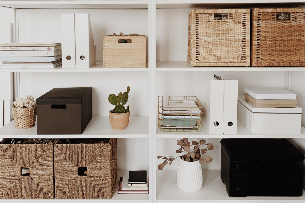 Organized home office shelving with baskets, boxes, files, and decor styled for a calm and functional home system.